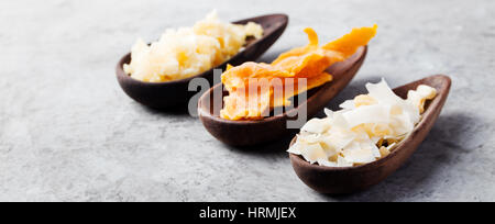 Gesunde Snacks. Getrocknete Mango, Kokos-Chips und Palmzucker in Holzschalen. Grauen Stein Hintergrund. Textfreiraum Stockfoto