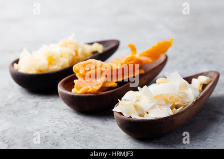 Gesunde Snacks. Getrocknete Mango, Kokos-Chips und Palmzucker in Holzschalen. Grauen Stein Hintergrund. Textfreiraum Stockfoto