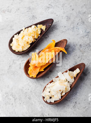 Gesunde Snacks. Getrocknete Mango, Kokos-Chips und Palmzucker in Holzschalen. Grauen Stein Hintergrund. Textfreiraum Stockfoto