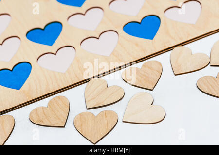 Geschnitzte kleine Holzherzen auf Tisch. Close-up Stockfoto