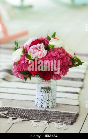 Schöne Hochzeit Bouquet mit Rosen und Pfingstrosen auf dünnen gestreiften Teppich am Boden. Close-up. Stockfoto