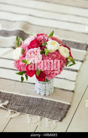 Schöne Hochzeit Bouquet mit Rosen und Pfingstrosen auf dünnen gestreiften Teppich am Boden. Close-up. Stockfoto