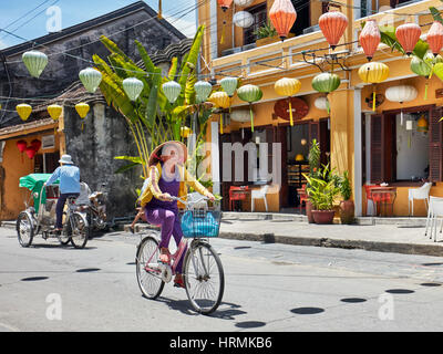 Frau fährt Rad in Hoi An Ancient Town. Provinz Quang Nam, Vietnam. Stockfoto