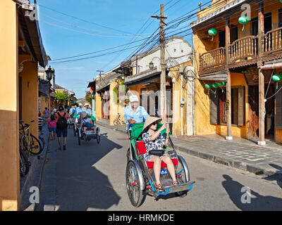 Touristen, die in der Altstadt von Hoi an in Pediküre reiten. Hoi An, Provinz Quang Nam, Vietnam. Stockfoto