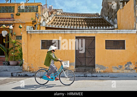 Frau auf dem Fahrrad in Hoi An Ancient Town. Provinz Quang Nam, Vietnam. Stockfoto