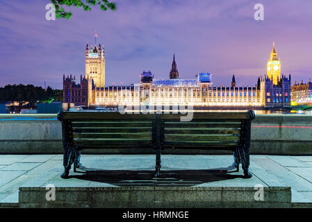 Bank in der Nacht mit Houses of Parliament in der Ferne Stockfoto