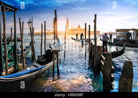 Venezianische Gondeln in Italien, Sonnenuntergang hinter der Kirche San Giorgio Maggiore Stockfoto