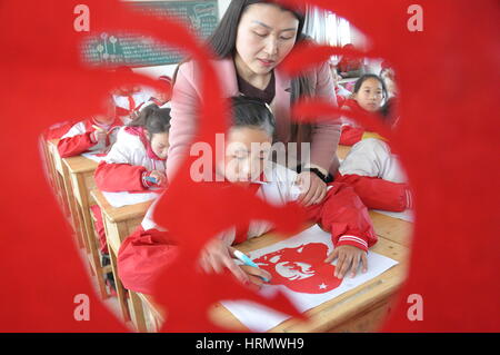 Lianyungang, Lianyungang, China. 2. März 2017. Lianyungang, CHINA-2. März 2017: (nur zur redaktionellen Verwendung. CHINA HERAUS). Schüler machen Papierschnitten von Lei Feng Porträt in Donghai, der ostchinesischen Provinz Jiangsu, 2. März 2017. Lei Feng war ein Soldat der Befreiung Armee von China und starb im Alter von 22 Jahren im Jahr 1962. Er nationale Berühmtheit und wurde zu einer Ikone des altruistischen Geist im Jahre 1963 als die verstorbenen chinesischen Führer Mao Zedong schrieb '' folgen dem Beispiel der Genosse Lei Feng'' und 5 März als das Jubiläum für das Lernen von Lei Feng gesetzt wurde. Bildnachweis: SIPA Asien/ZUMA Draht/Alamy Live-Nachrichten Stockfoto