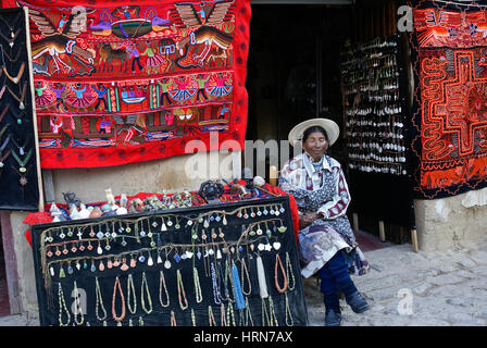 Verschlafene Quechua-Frau verkauft Kunsthandwerk in Ollantaytambo, Peru Stockfoto