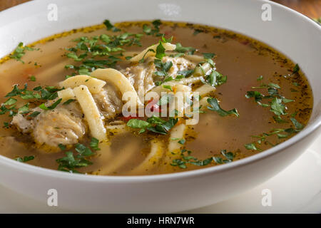 Hühnersuppe mit Nudeln und Kräutern in Schüssel weiß Stockfoto