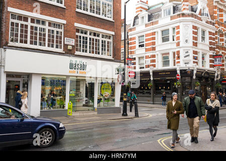 Passanten in der Wardour Street, Soho vor eine lokale Niederlassung der japanischen Restaurant Wasabi. London, UK Stockfoto