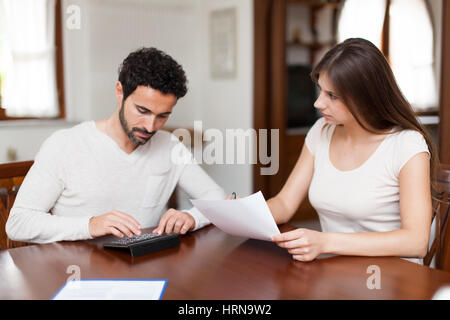 Steuern, Finanzen, Familie, Heimat und Glück Konzept - busy paar mit Papieren und Rechner zu Hause Stockfoto