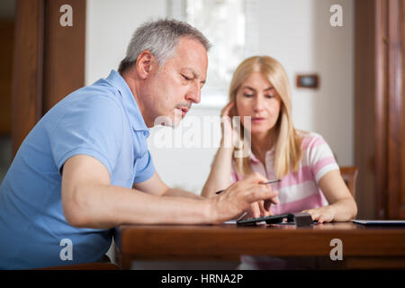 Älteres Paar, ihre Rechnungen zu Hause arbeiten Stockfoto