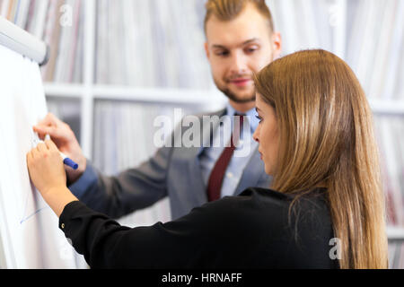 Seitenansicht der zwei junge Unternehmer arbeiten am Flipchart im Büro Stockfoto