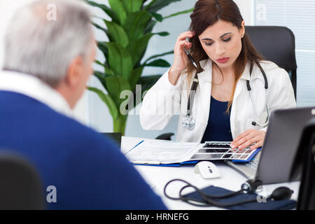 Patienten, die während eines Besuchs im Gespräch mit ihrem Arzt Stockfoto