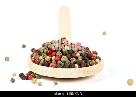 Kochlöffel mit gemischte Pfefferkörner isoliert auf weißem Hintergrund Stockfoto