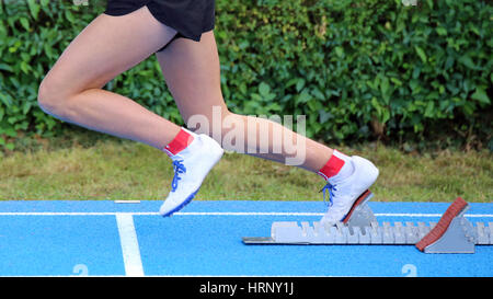 Junge Sportler startet vom Startblock ein Rennen in Leichtathletik Stockfoto