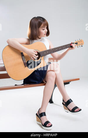 Junge Frau Gitarre spielen Stockfoto