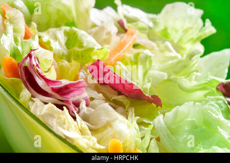 frischen Salat in eine Schüssel geben Stockfoto