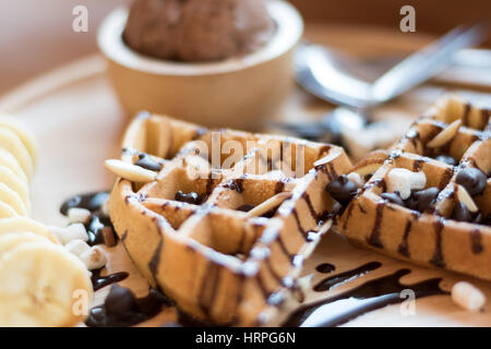Belgische Waffeln mit Erdbeere, Kirsche, Heidelbeere und Schokoladensauce. Stockfoto
