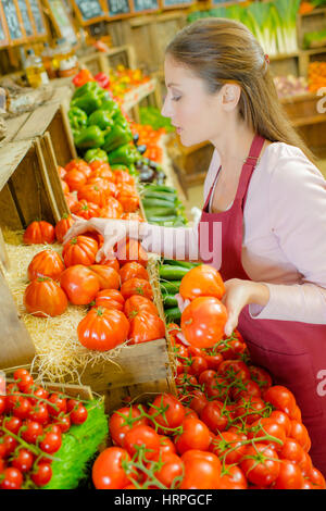 Shop Mitarbeiter tragen eine Kiste Tomaten Stockfoto