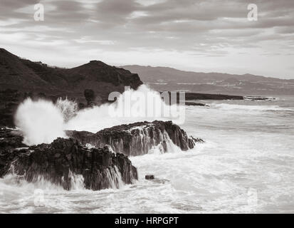 Riesige Wellen, die über Basaltfelsen auf die schroffen, vulkanischen Norden Küste von Gran Canaria, Kanarische Inseln, Spanien Stockfoto