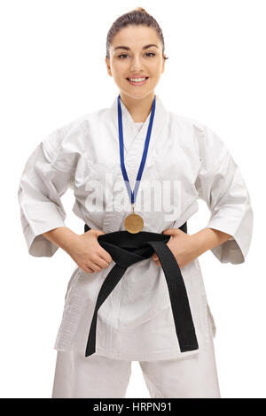 Karate Girl mit einer Goldmedaille lächelt und schaut in die Kamera, die isoliert auf weißem Hintergrund Stockfoto