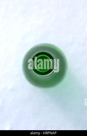 grüne Flasche auf dem Schnee Stockfoto