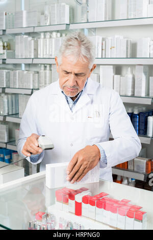 Ältere männliche Chemiker Scannen von Barcodes auf Medizin-Box in der Pharmazie Stockfoto