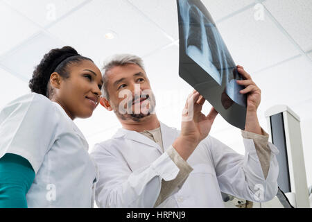 Niedrigen Winkel Ansicht der männlichen und weiblichen Radiologen Analyse Röntgen im Untersuchungsraum Stockfoto
