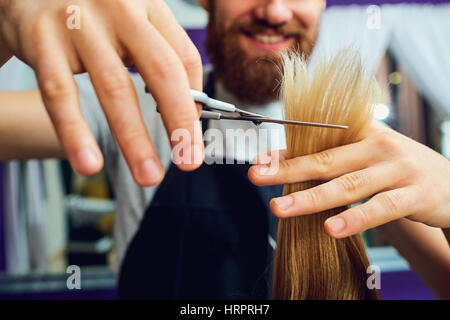 Close-up Konzept Friseur Friseursalon. Hände mit Friseur Schere schneiden ihre Kundenhaar. Stockfoto