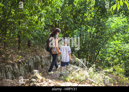Mutter und Sohn auf eine Gasse im Wald absteigend Stockfoto