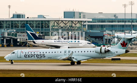 Air Canada Express (Jazz Aviation) und WestJet Flugzeuge am Flughafen Vancouver International Airport. Stockfoto