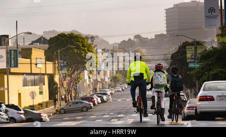 Ein Vater und Kinder, die am Morgen auf dem Weg zum Hotel Fahrrad fahren, fahren im Inner Sunset District von San Francisco, CA, Kalifornien, USA Stockfoto