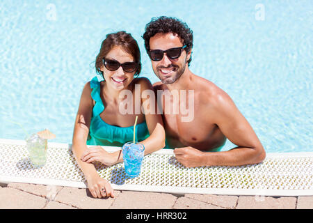 Brautpaar mit Cocktails in den pool Stockfoto