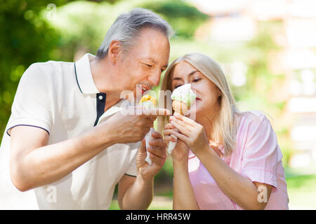 Glückliches Paar Essen ein Eis in einem park Stockfoto