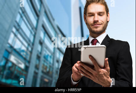 Porträt eines Geschäftsmannes, der mit seinem Tablettcomputer Stockfoto