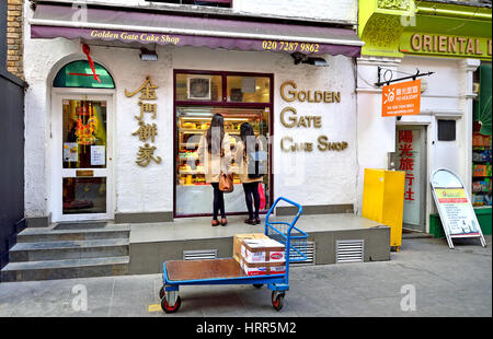 London, England, Vereinigtes Königreich. Zwei chinesische Frauen auf der Suche in einem Kuchen-Schaufenster in Chinatown Stockfoto