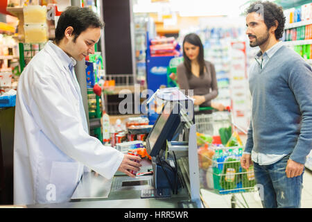 Mann an der Kasse in einem Supermarkt Stockfoto