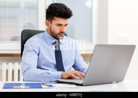 Porträt eines Geschäftsmannes, der mit seinem laptop Stockfoto