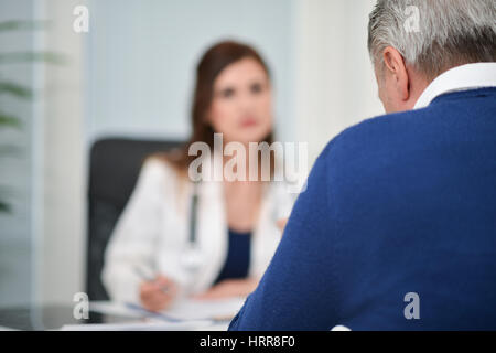Patienten, die während eines Besuchs im Gespräch mit seinem Arzt Stockfoto