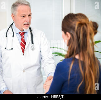 Arzt geben ein Händedruck, ein Patient in seinem Atelier Stockfoto