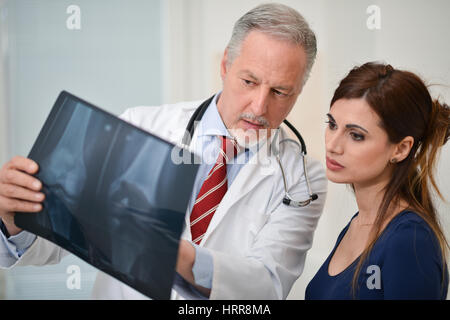 Arzt zeigt eine Radiographie zu seinen Patienten in seinem Atelier Stockfoto