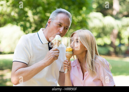 Porträt einer glücklich älteres paar Essen ein Eis in einem park Stockfoto