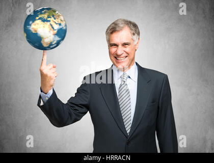 Unternehmer, die einen Globus an seinem Finger drehen Stockfoto