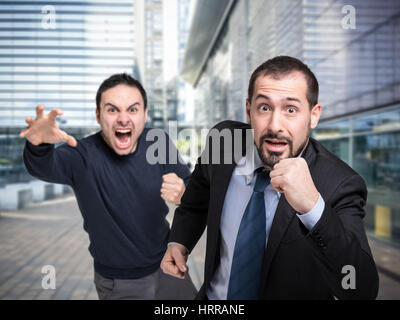 Unternehmer, die auf der Flucht vor einem wütenden Kunden Stockfoto