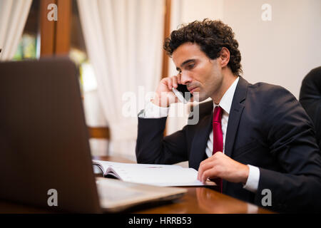 Porträt eines Geschäftsmannes in seinem Büro telefonieren Stockfoto