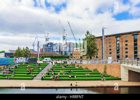 LONDON - 22 AUGUST: Dies ist eine Ansicht der Granary Square mit Menschen sitzen am Fluss entlang der Regents Canal und der Central Saint Martins-Universität-ca Stockfoto