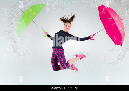 Frau im Sprung mit einem Regenschirm. Gefrorene Bewegung. Stockfoto