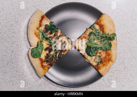 Zwei Scheiben von Pizza in minimalistischem Ambiente Stockfoto
